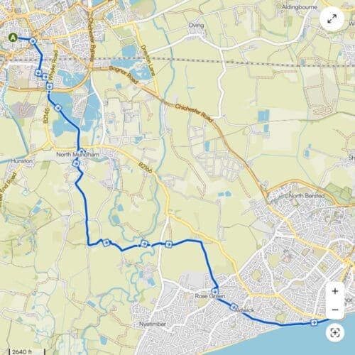 Screenshot of a map of the Chichester and Bognor area. A blue line with directional arrows marks out a route across countryside heading south east, ending at the coast.