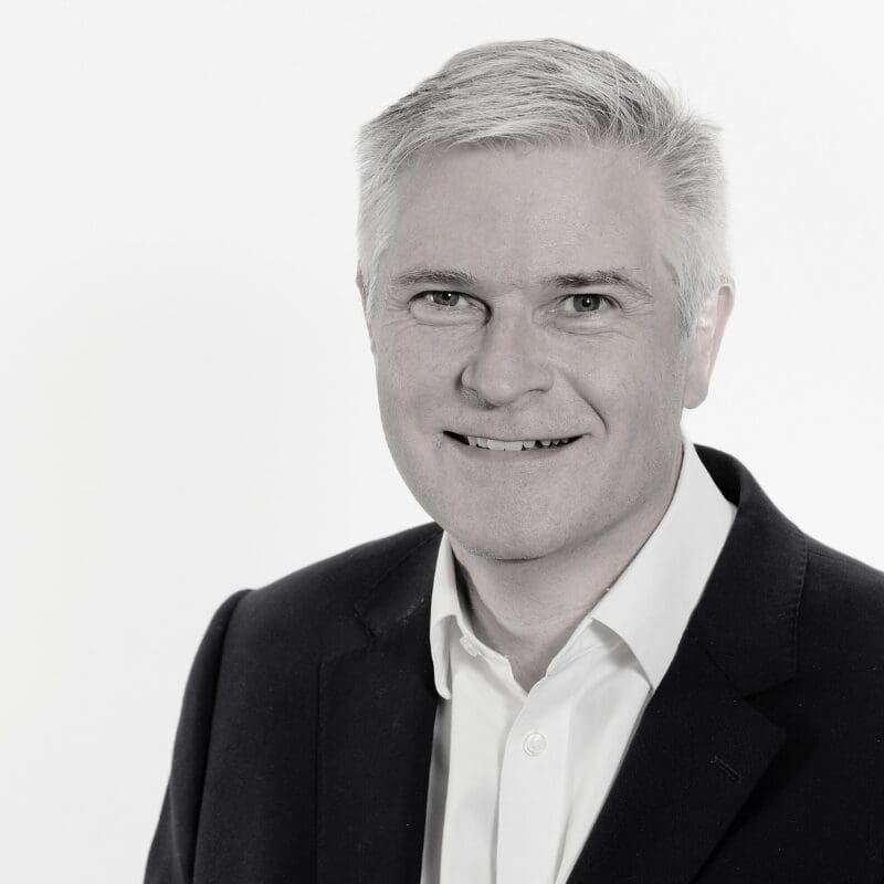 Rob is a white man with short silver hair. He has a friendly grin.